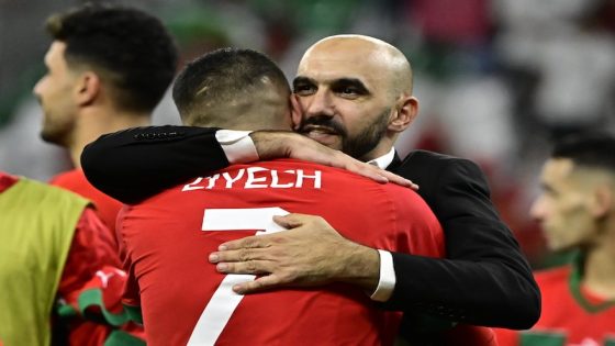 Morocco's coach #00 Walid Regragui (R) embraces Morocco's midfielder #07 Hakim Ziyech after winning the Qatar 2022 World Cup round of 16 football match between Morocco and Spain at the Education City Stadium in Al-Rayyan, west of Doha on December 6, 2022. (Photo by JAVIER SORIANO / AFP)
